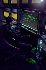 Fototapeta na wymiar Hacker is working with computer typing text in dark room.