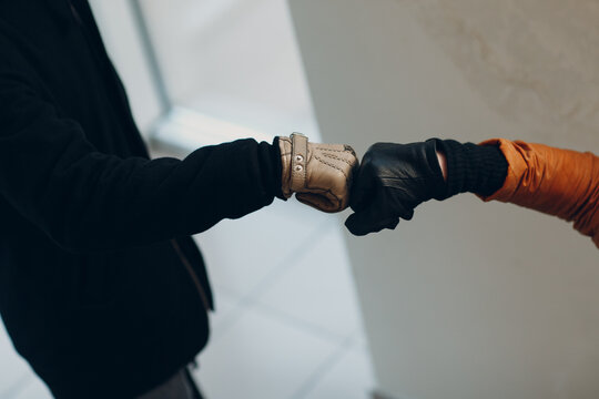Fist hand in glove bumping safety greeting of coronavirus COVID-19 pandemia. New normal.