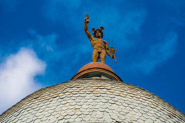 Obraz premium Statue of Mercury on top of the roof of a building in Novi Sad, Serbia