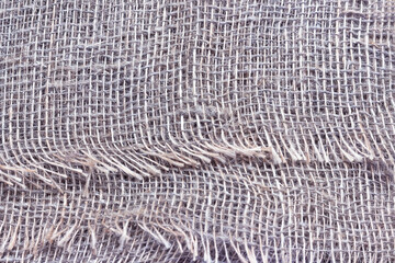 Natural burlap with large cells. The texture of a coarse woven fabric with mesh and fibers.