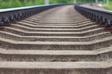 Railway rails and sleepers close-up. A railway that goes around a bend in the distance.