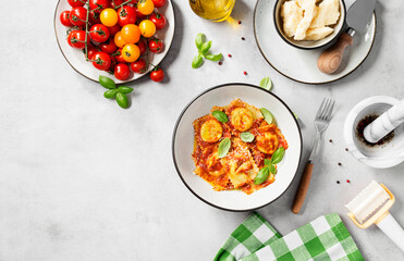 Homemade italian ravioli pasta, stuffed with spinach and ricotta ,served  with tomato sauce, parmesan cheese and fresh basil leaves . Space for text. Top view
