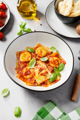 Homemade italian ravioli pasta, stuffed with spinach and ricotta ,served  with tomato sauce, parmesan cheese and fresh basil leaves .