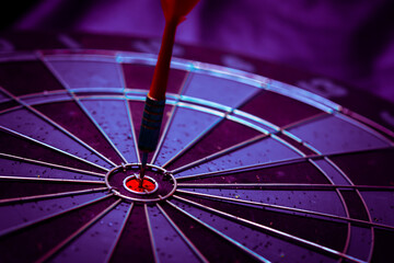 Close up shot of the dart arrow hit on bulleyes of dartboard to represent that the business reached...