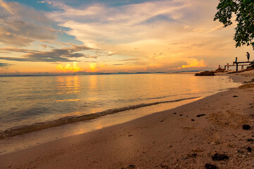 Nature in twilight period which including of sunrise over the sea and the nice beach. Summer beach with blue water and purple sky at the sunset.	
