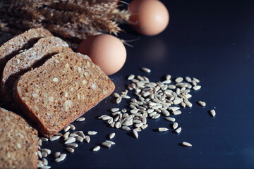 Fresh loaves of bread with wheat and gluten on a black table. Bakery and grocery concept. Fresh,...