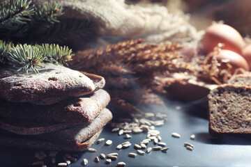 Fresh loaves of bread with wheat and gluten on a black table. Bakery and grocery concept. Fresh, healthy sorts of rye and white loaves food closeup. Fresh homemade bread with cereals.