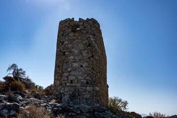 Naklejka premium ancient stone mills and their ruins on the slopes of the mountains in Crete on a sunny day