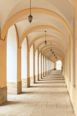 Long street gallery with arches, columns and lanterns. Vertical