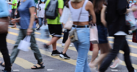 blurred Busy crowds of men and women or Commuters Crossing Street in Central, Hong Kong, with Crosswalk yellow lines. zebra yellow pedestrian crossing