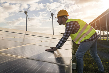 Man working for solar panels and wind turbines - Renewable energy concept - Focus on male worker hands © DisobeyArt