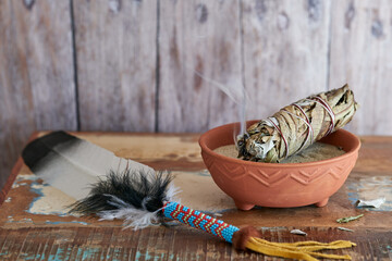 Smudge Stick Weißer Salbei und Yerba Santa in einer Tonschale mit Räucherfeder
