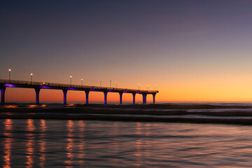 Fototapeta na wymiar New Brighton Pier during colorful sunrise morning. Christchurch city, New Zealand