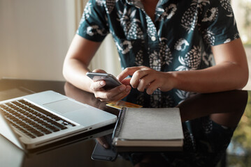 Online payment of hands of women holding smartphones and using credit cards and laptop computers for online shopping.