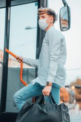 Muchacho joven subiendo al autobús con mascarilla y cumpliendo la distancia de seguridad © Migue Suarez