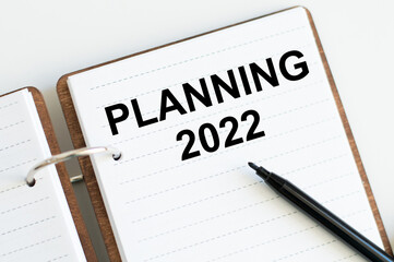 Planning 2022- text written on notepad on white background. Business motivation, inspection concepts ideas. 2022 New Year.