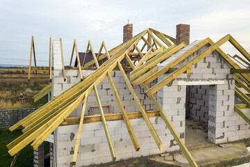 Aerial view of a private house with aerated concrete brick walls and wooden frame for future roof.