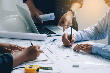 Engineer Teamwork Meeting, Engineers discussing on a project and working on blueprint meeting for project working with a partner at the construction site at desk in the office, Construction concept.