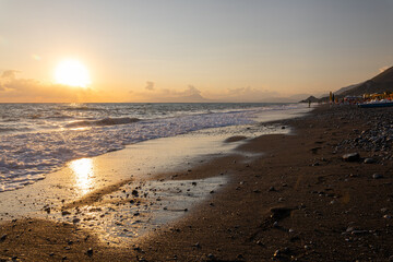 Beautiful sunset on beach. Golden light shines on sea water