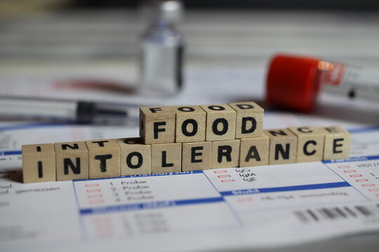 Viersen, Germany - June 1. 2021: Closeup of word food intolerance on laboratory requisition slip with syringe and vial