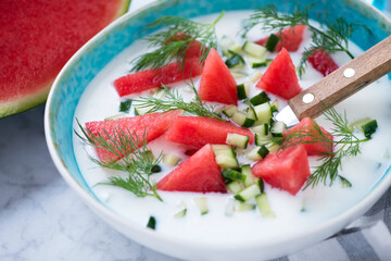 Turquoise bowl of cold summer soup made of watermelon, cucumber, buttermilk and dill, close-up, selective focus