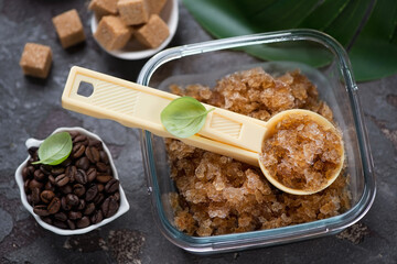 Glass container with coffee granita and a serving spoon, studio shot on a brown stone background