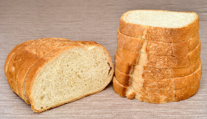 Stack of sliced fresh homemade white bread on the rustic wooden table.