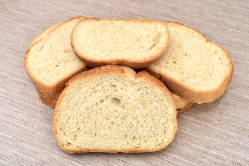 Stack of sliced fresh homemade white bread on the rustic wooden table.