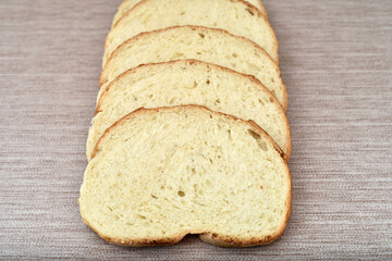 Stack of sliced fresh homemade white bread on the rustic wooden table.