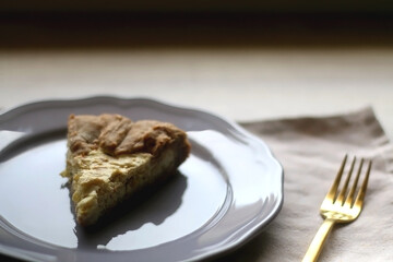 Slice of cheese and leek quiche on wooden table. Selective focus.