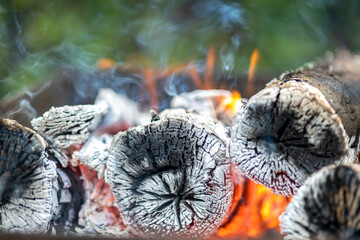 Close up of brightly burning wooden logs with yellow hot flames of fire.