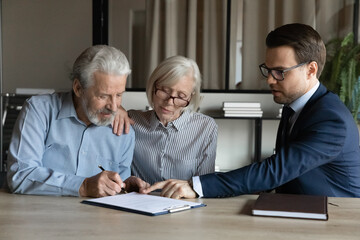 Fototapeta premium Mature couple signing contract, making insurance investment deal with manager broker or realtor in office, businessman in glasses consulting senior family, pointing finger at document agreement