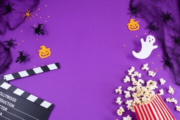 Movie Clapper board in spider webs, spiders, ghost, eyes on purple Lilac Background.