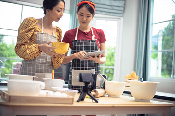 Two women are discussing and preparing an online cooking class.