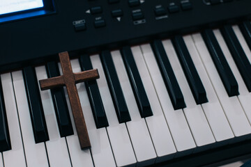 Wooden cross on piano keys, top view