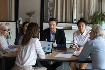 Diverse employees listening to confident businessman coworker at briefing, business partners...