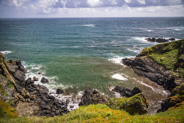 Fototapeta na wymiar Waves crashing on to rocks at Lizard Point, Cornwall, England