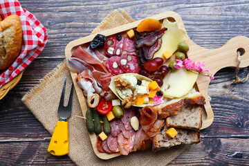 Charcuterie and cheese on wooden board, antipasti assortment , cold cut assorted meat with cheeses and mini baguette on side - Top view of appetizer snack