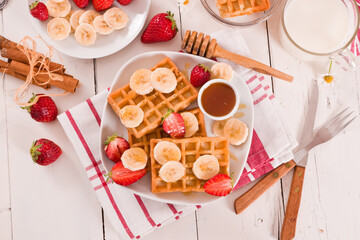 Waffles with strawberries, bananas and honey.