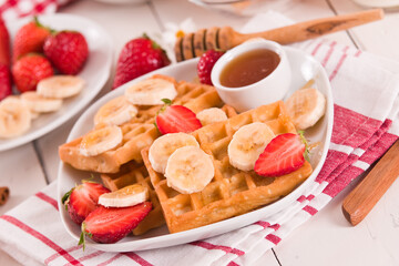 Waffles with strawberries, bananas and honey.