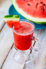 Delicious healthy refreshing low calories summer drink: watermelon smoothie or juice. Concept of seasonal desserts, detox, dieting. White wooden background, close up, macro