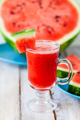 Delicious healthy refreshing low calories summer drink: watermelon smoothie or juice. Concept of seasonal desserts, detox, dieting. White wooden background, close up, macro