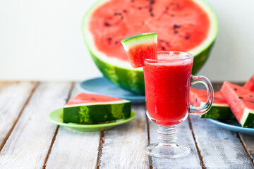 Delicious healthy refreshing low calories summer drink: watermelon smoothie or juice. Concept of seasonal desserts, detox, dieting. White wooden background, close up, macro
