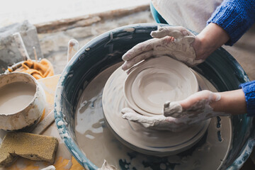 manual labor on a potter's wheel. dirty hands of the master