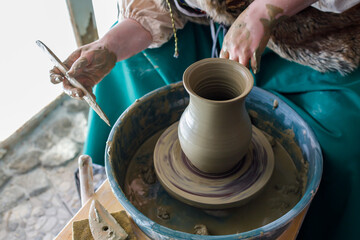 the process of creating a jug from clay on a potter's wheel