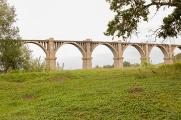 Fototapeta na wymiar Mokrinsky railway bridge is a historical reinforced concrete arched viaduct, a railway crossing over the Utka river, located in the village of Mokry, Kanashsky district of the Chuvash Republic. Summer