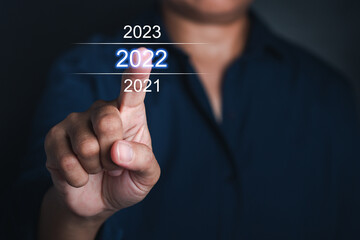 Businessman pointing to digital 2022 calendar. Countdown to 2022 concept. Space for text.