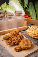 fried chicken with french fries on a wooden chopping board