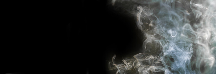 Thick smoke from burning incense on a black background. Banner for design and advertising, panoramic shot. Horizontal format. Copyspace