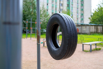 black car tire hanging on the playground